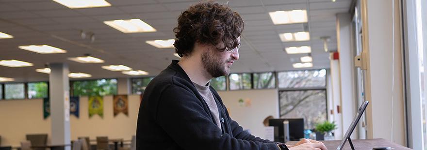一位西雅图州立大学的学生在Lower Weter通勤休息室用笔记本电脑工作